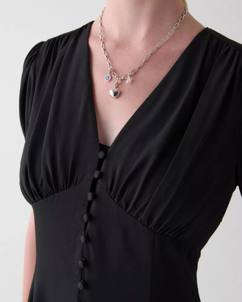 vestido curto preto com mangas bufantes e modelagem fluida
