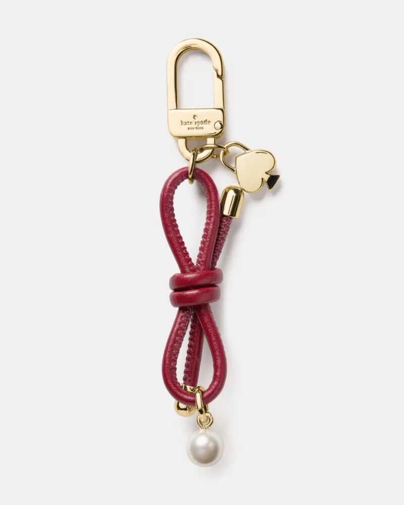 pingente de bolsa com laço e pérolas artificiais cor vermelho geleia.