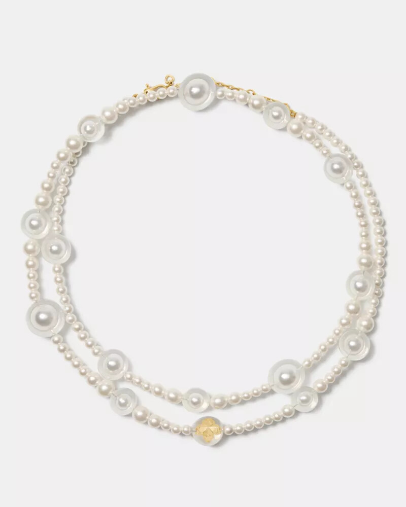 colar longo statement com pérolas em formato de flor de espadas e detalhes em ouro branco.