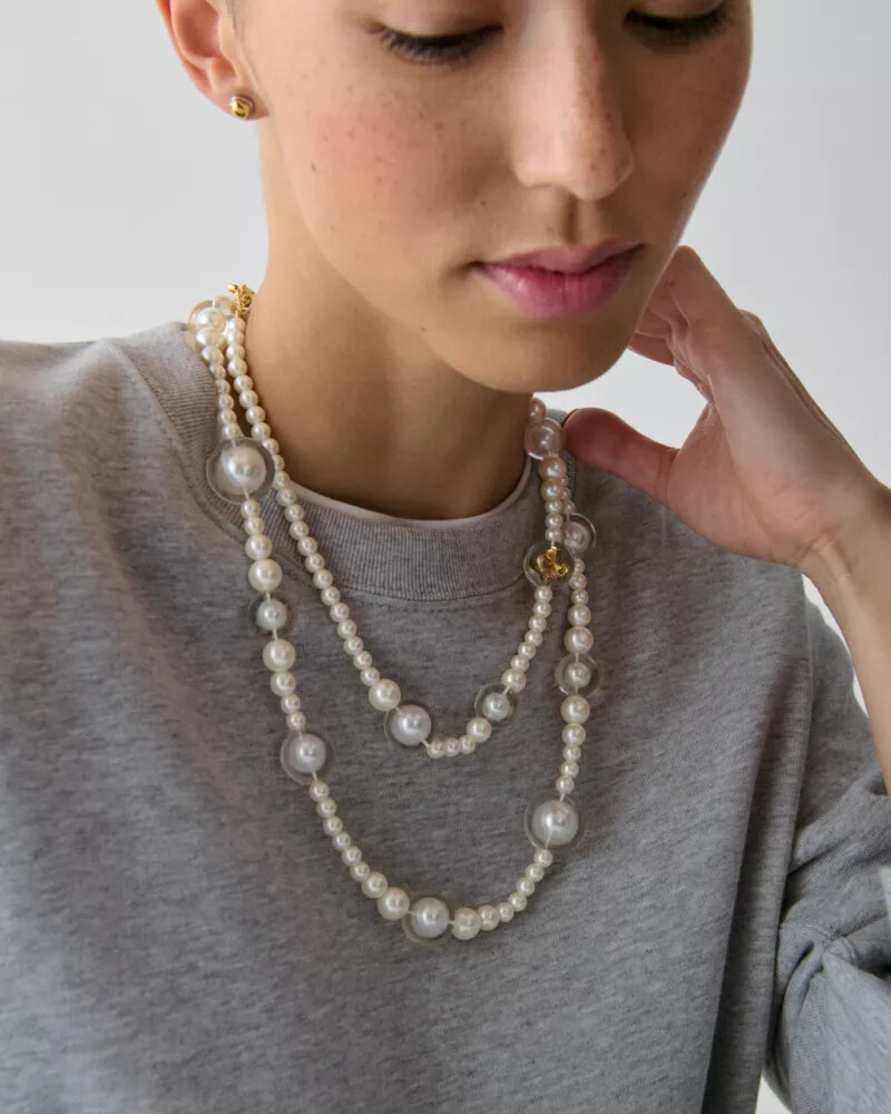 colar longo statement com pérolas em formato de flor de espadas e detalhes em ouro branco.