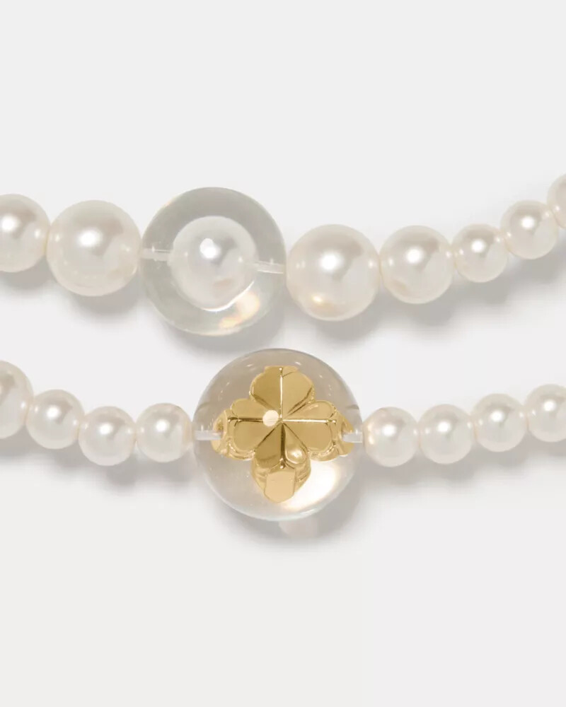 colar longo statement com pérolas em formato de flor de espadas e detalhes em ouro branco.