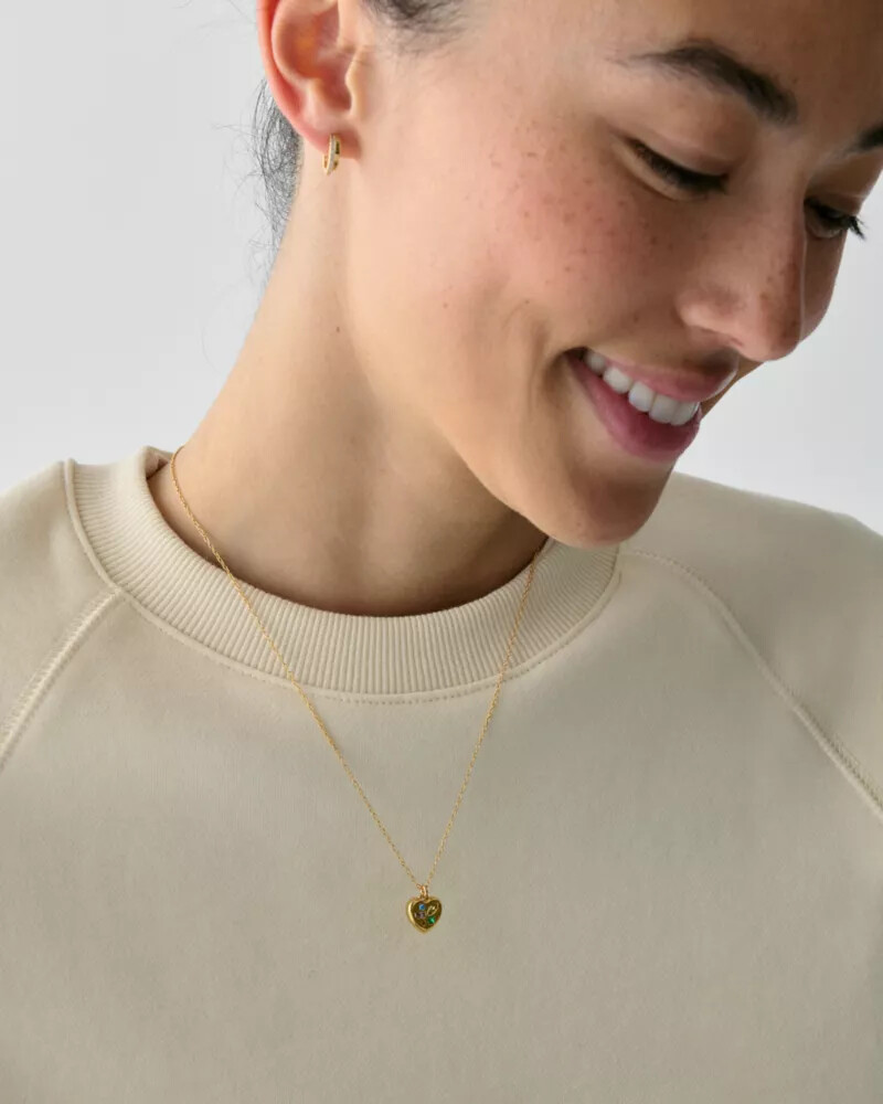 pingente self-love club em formato de cartão dourado multicolorido.