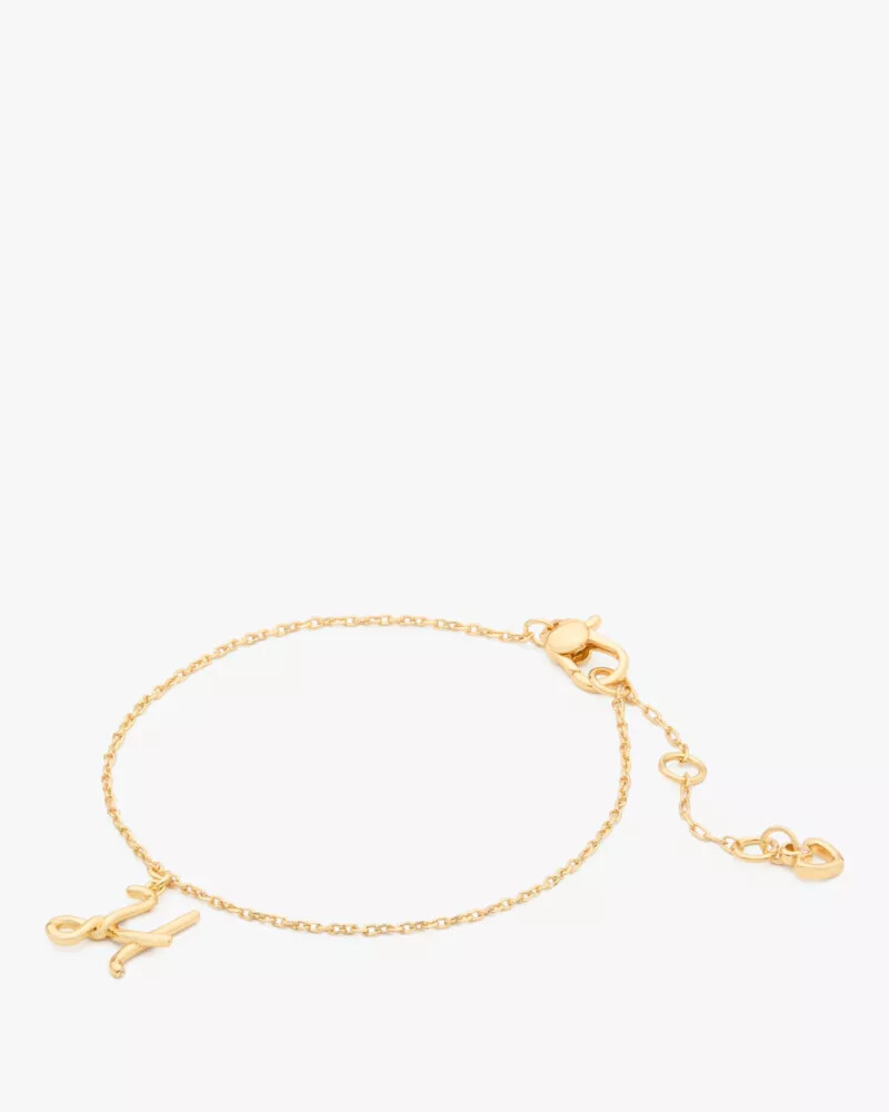 pulseira dourada com inicial em estilo cursivo
