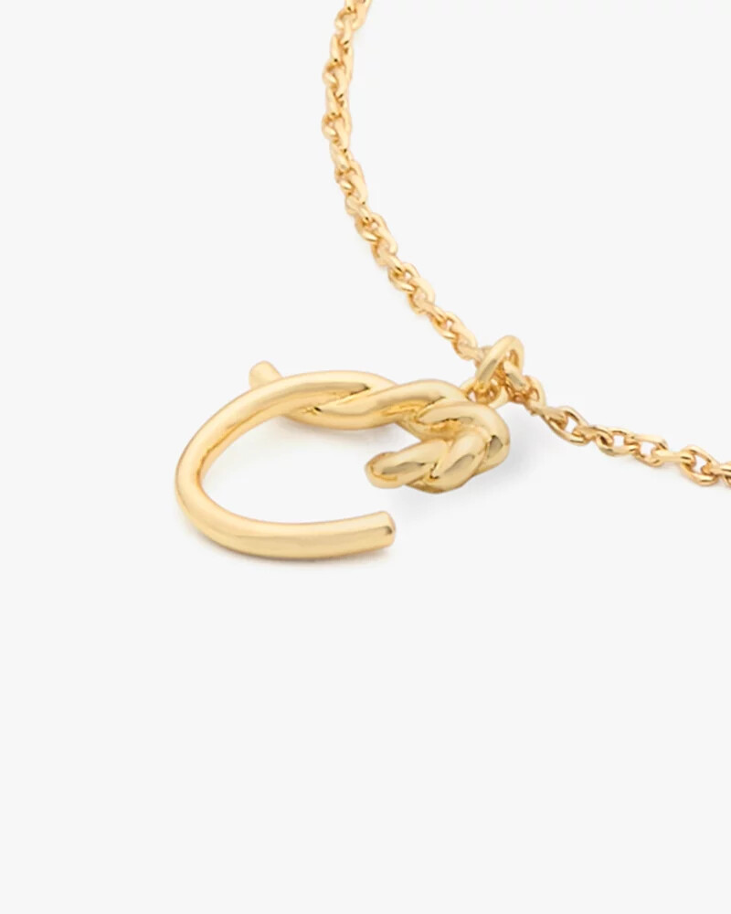 pulseira dourada com inicial em estilo cursivo