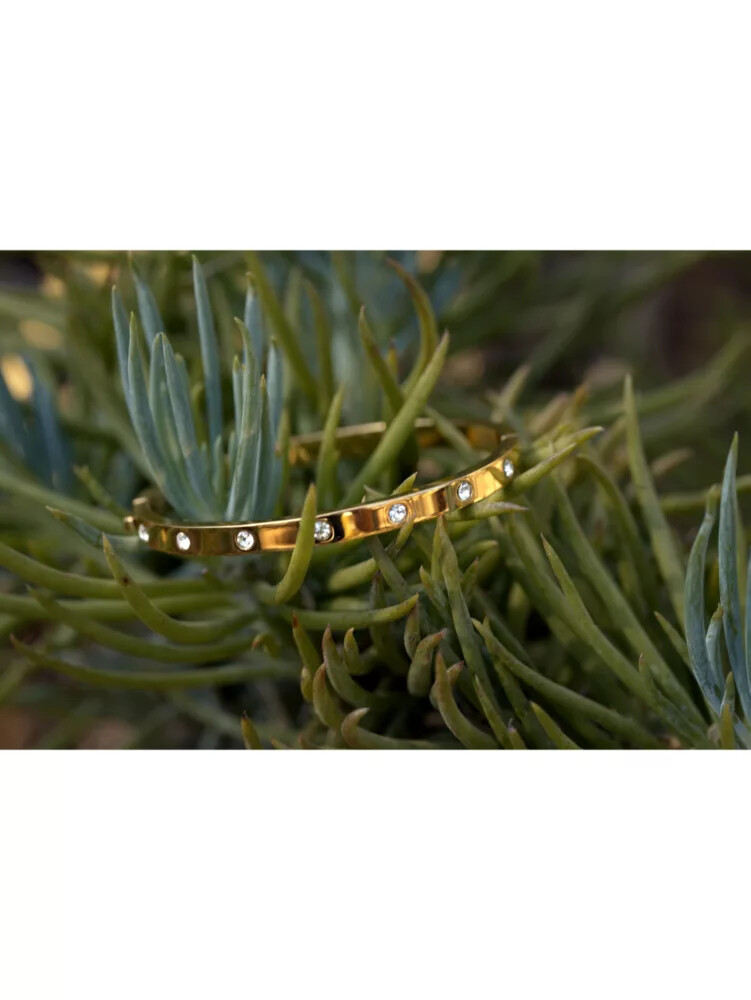 pulseira articulada dourada com detalhes em pedra.