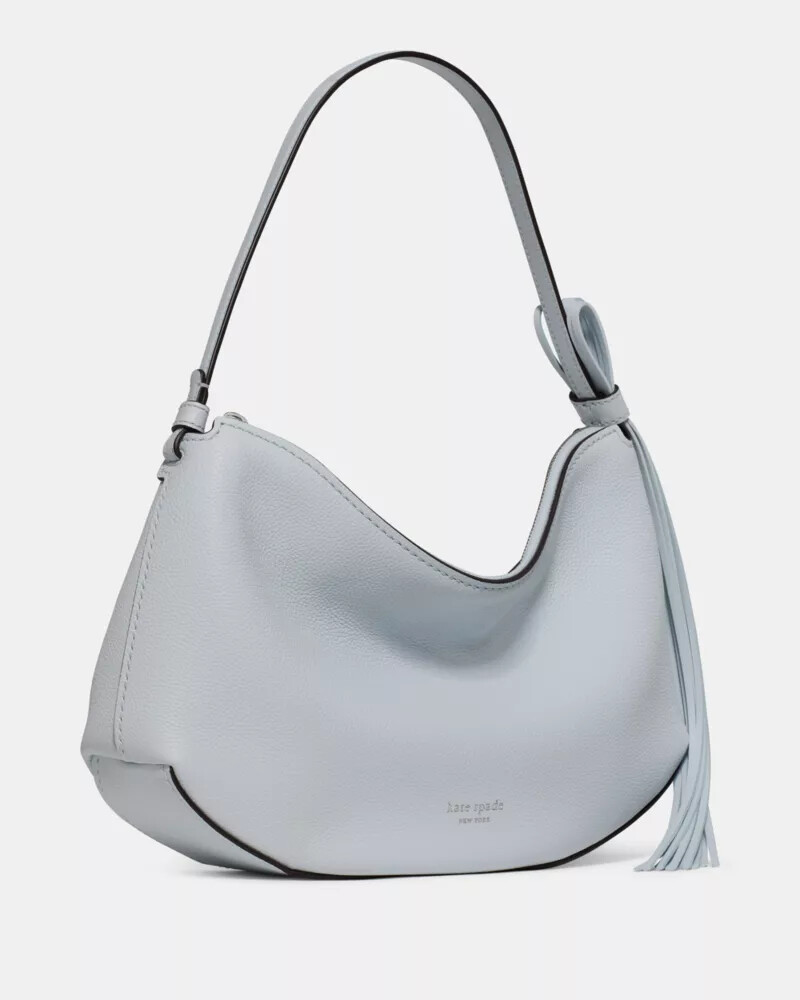 bolsa de ombro com alça de franjas em formato de laço cor safira clara.