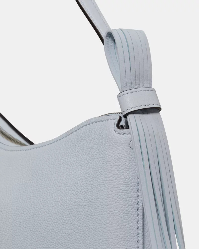 bolsa de ombro com alça de franjas em formato de laço cor safira clara.